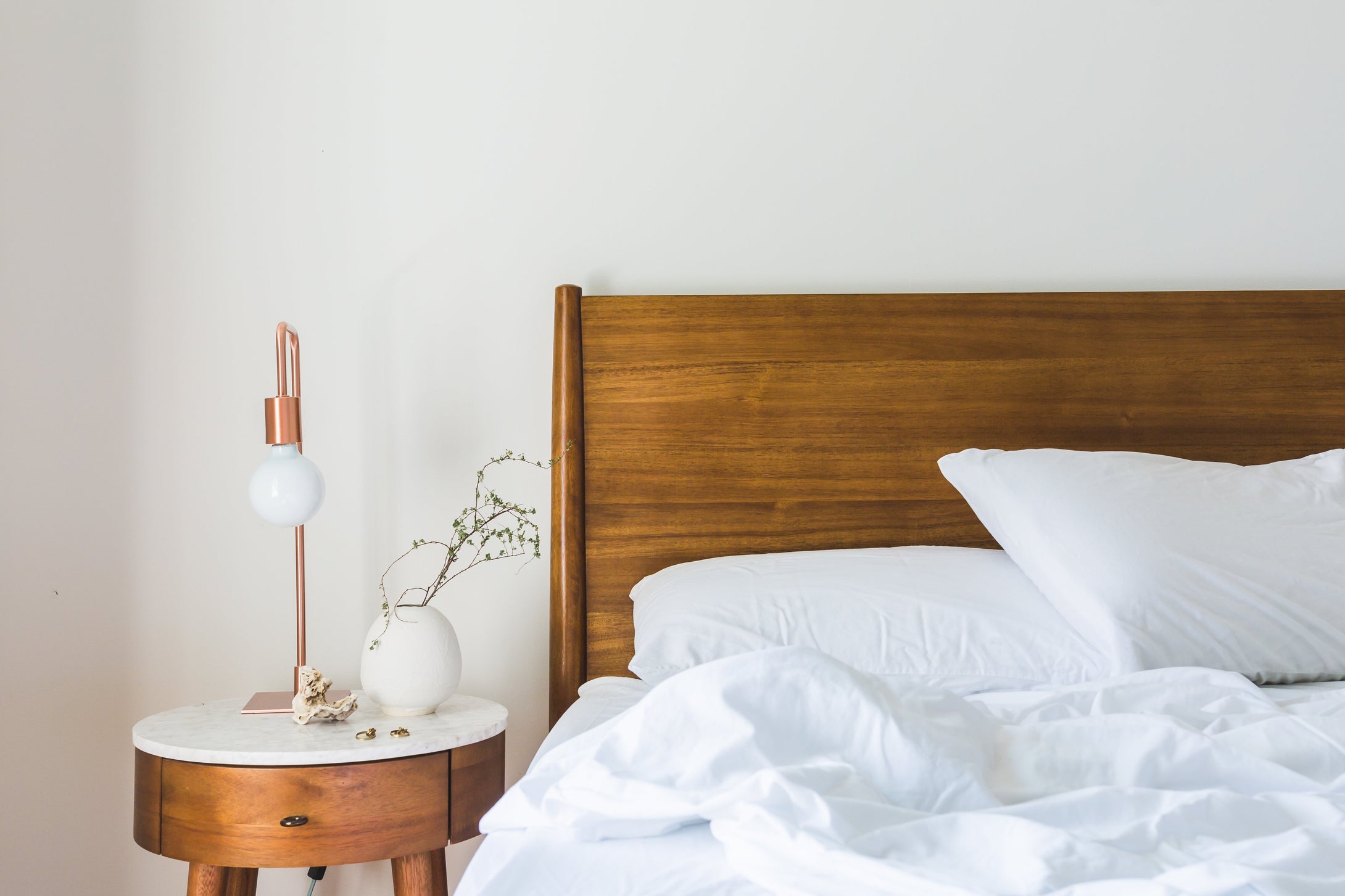 Adding a copper table lamp into a bedroom can add a feeling of warmth and softness. This image shows how a copper table lamp can work within a Scandinavian style modern bedroom interior within a home.